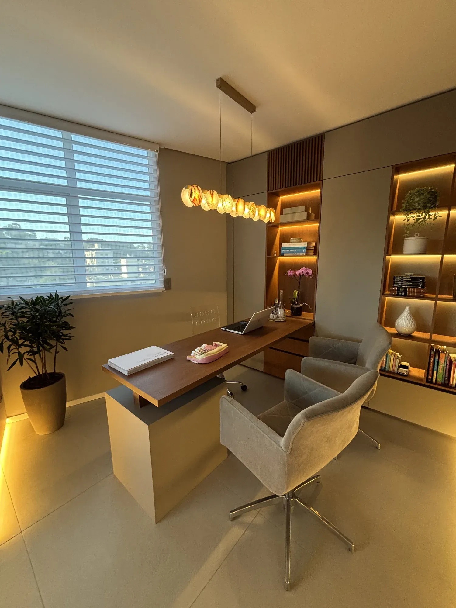 Sala de consulta da LINEARE, com a janela e a luminária sobre a mesa.